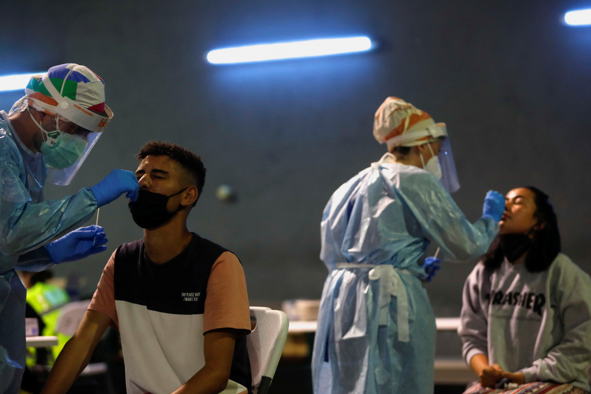 Health workers take swabs during a voluntary antigen test for the coronavirus disease (COVID-19) of young people coming back from vacationing in Salou at the bus station in Pamplona, Spain, July 4, 2021. REUTERS/Susana Vera
