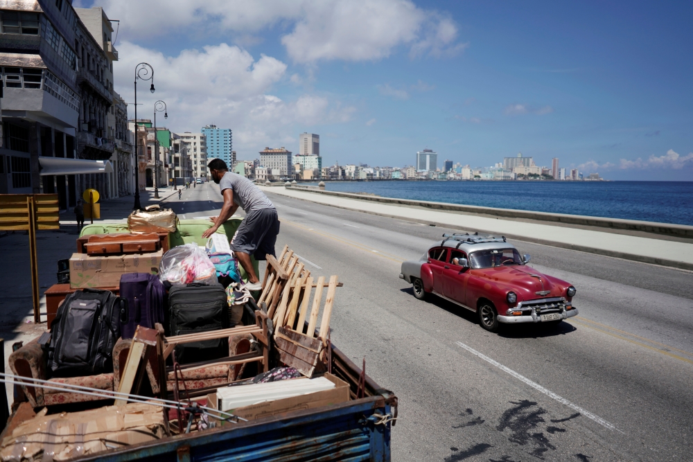 A man loads a truck with furniture to be relocated prior to the arrival of Storm Elsa, in Havana, Cuba, July 4, 2021. REUTERS/Alexandre Meneghini
