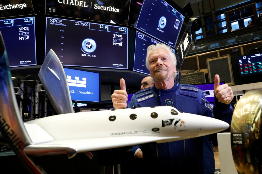 FILE PHOTO: Sir Richard Branson poses on the floor of the New York Stock Exchange (NYSE) ahead of Virgin Galactic (SPCE) trading in New York, U.S., October 28, 2019. REUTERS/Brendan McDermid