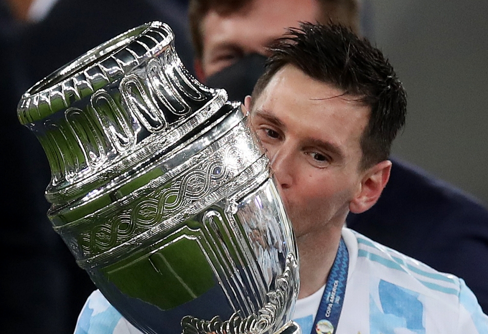July 10, 2021 Argentina's Lionel Messi celebrates winning the Copa America as he kisses the trophy REUTERS/Ricardo Moraes