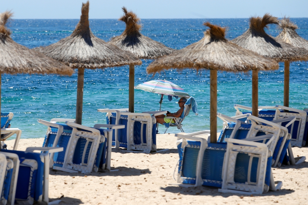 FILE PHOTO: A tourist enjoys the weather at Magaluf beach,  in Palma de Mallorca, Spain, July 1, 2021. REUTERS/Enrique Calvo