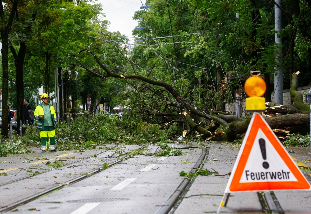 A view of a tree that fell on the overhead wire of a tram line during thunderstorms and torrential rain in Zurich, Switzerland July 13, 2021. REUTERS/Arnd Wiegmann