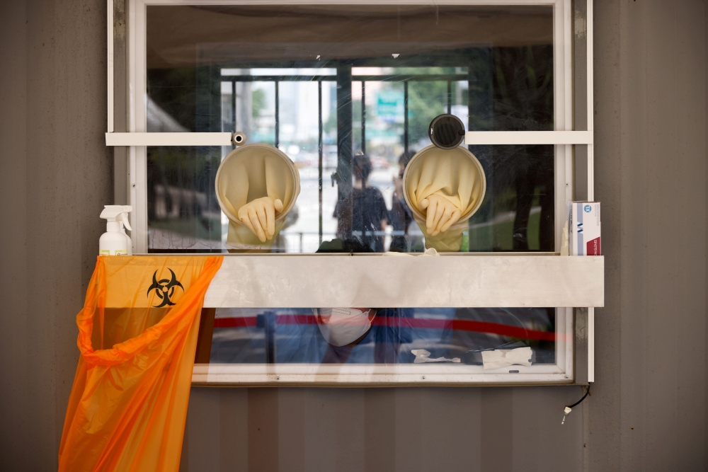 A health worker rests inside a booth as she conducts a coronavirus disease (COVID-19) test at a coronavirus testing site in Seoul, South Korea, July 15, 2021. REUTERS/Kim Hong-Ji