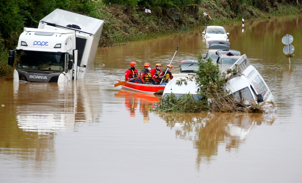 Rescue team paddle along flooded cars stuck on the road following heavy rainfalls in Erftstadt, Germany, July 16, 2021. REUTERS/Thilo Schmuelgen/File Photo