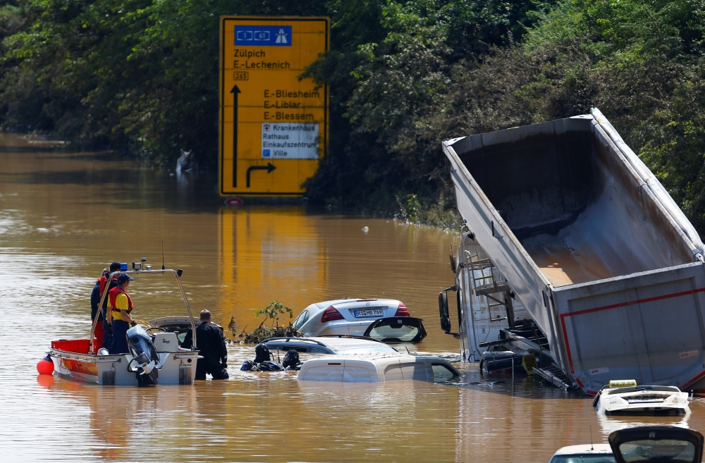 Divers from German Life Saving Association (DLRG) search at a flooded road following heavy rainfalls in Erftstadt-Blessem, Germany, July 17, 2021. (REUTERS/Thilo Schmuelgen)