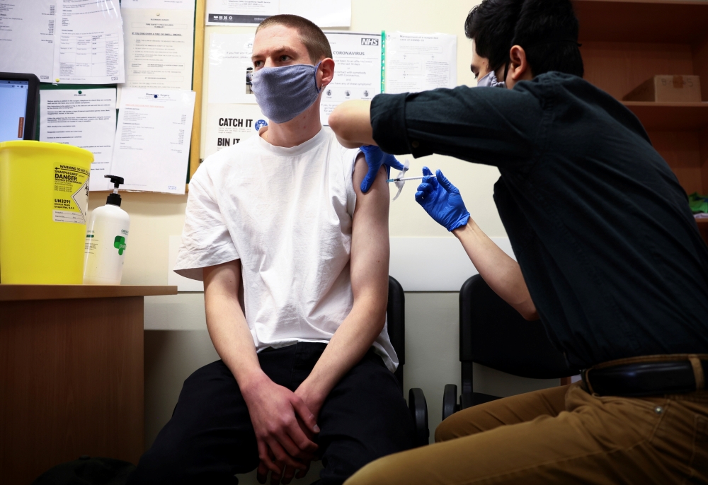 A person receives a dose of the Pfizer BioNTech vaccine, at vaccination centre for young people and students at the Hunter Street Health Centre, amid the coronavirus disease (COVID-19) outbreak, in London, Britain, June 5, 2021. REUTERS/Henry Nicholls/Fil