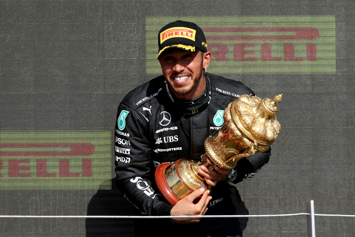 Formula One F1 - British Grand Prix - Silverstone Circuit, Silverstone, Britain - July 18, 2021 Mercedes' Lewis Hamilton celebrates on the podium with the trophy after winning the race REUTERS/Peter Cziborra
