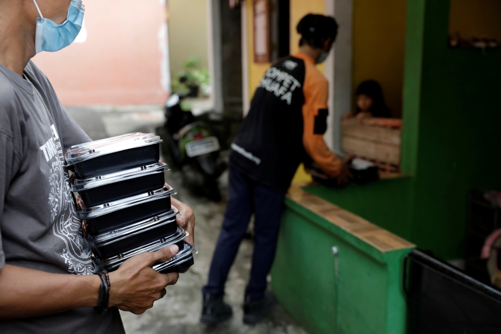 Volunteers of Indonesian NGO Dompet Dhuafa distribute free food to coronavirus disease (COVID-19) patients undergoing self-isolation in South Tangerang, on the outskirts of Jakarta, Indonesia, July 11, 2021. REUTERS/Willy Kurniawan