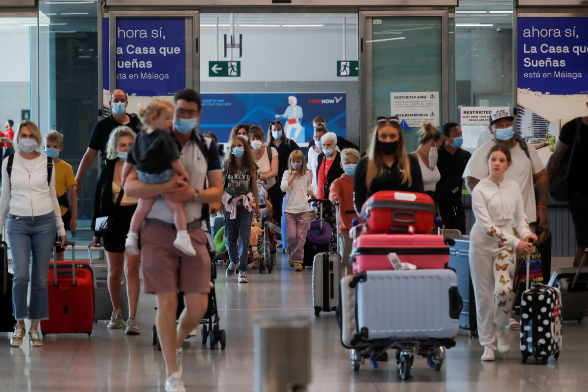British tourists wearing protective face masks walk with their luggage, as they arrive at Malaga-Costa del Sol Airport for sightseeing, amid the coronavirus disease (COVID-19) outbreak in Malaga, Spain, July 19, 2021. REUTERS/Jon Nazca
