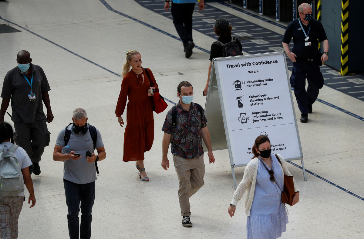 Commuters walk past a sign, amid the coronavirus disease (COVID-19) pandemic, in Waterloo station, London, Britain, July 19, 2021. REUTERS/Peter Nicholls
