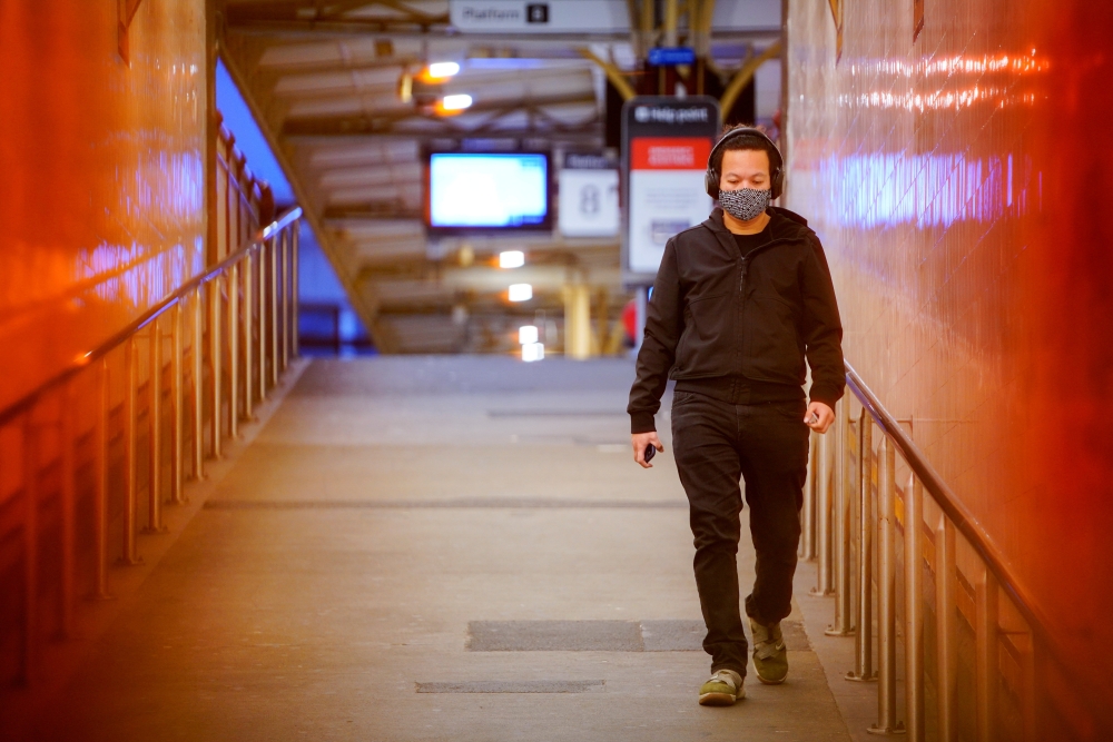 A lone passenger wearing a protective face mask walks from a deserted train platform at Flinders Street during morning commute hours on the first day of a lockdown as the state of Victoria looks to curb the spread of a coronavirus disease (COVID-19) outbr
