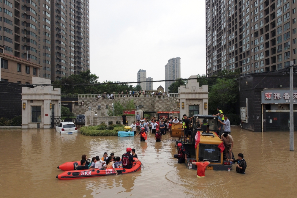 Rescue workers evacuate residents from a flooded residential compound following heavy rainfall in Zhengzhou, Henan province, China July 22, 2021. Picture taken with a drone. REUTERS/Aly Song