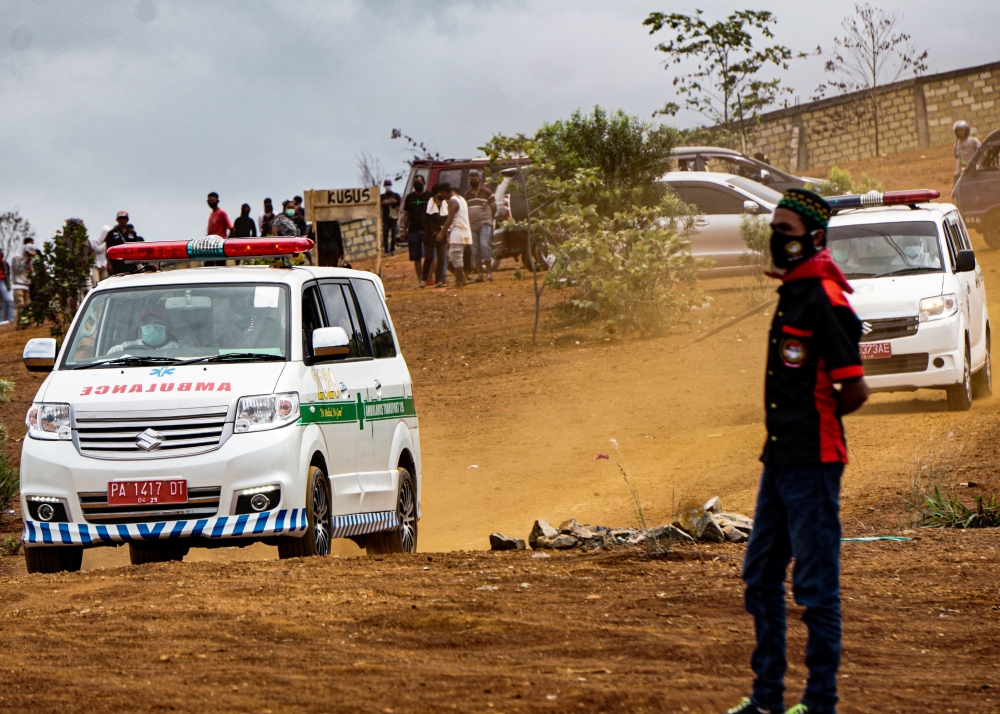 Ambulances are seen at a burial area provided by the government for coronavirus disease (COVID-19) victims, as cases surge in Jayapura, Papua, Indonesia July 20, 2021, in this photo taken by Antara Foto/Indrayadi TH/via REUTERS