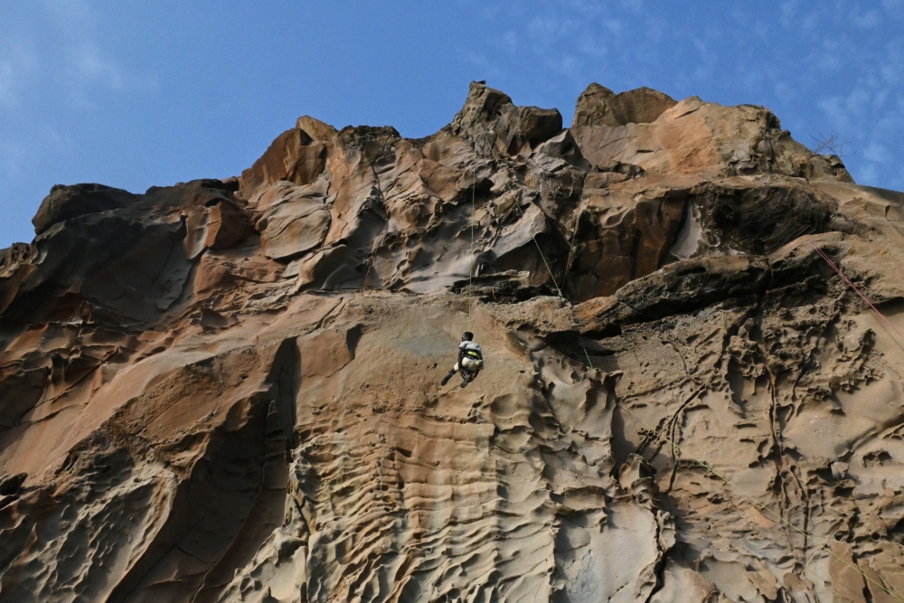 Senegalese rock climber Daouda Diallo is being lowered from a top of a rock wall at the Mamelles cliffs in Dakar, Senegal, June 27, 2021. Picture taken June 27, 2021.REUTERS/Cooper Inveen