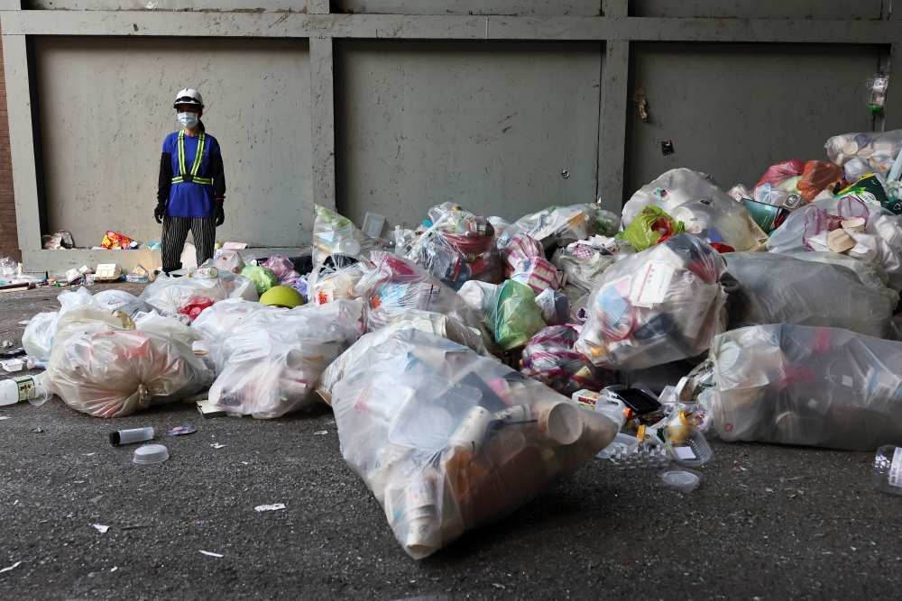 A staff member wearing a protective mask waits for trash trucks to arrive to the waste collection plant, following the coronavirus disease (COVID-19) outbreak in Taipei, Taiwan July 15, 2021. REUTERS/Ann Wang