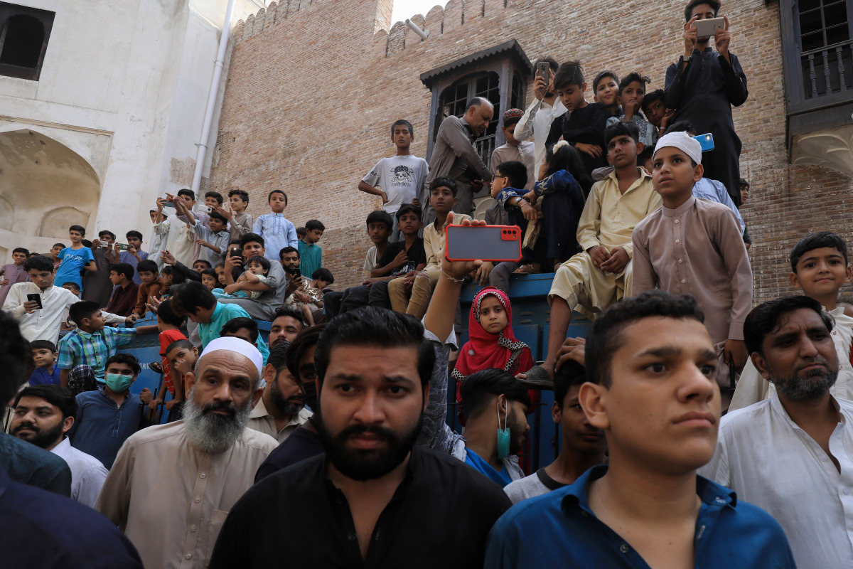 People gather to see a camel slaughtering in celebration of Eid al-Adha, as the outbreak of the coronavirus disease (COVID-19) continues, in Peshawar, Pakistan July 21, 2021. REUTERS/Fayaz Aziz
