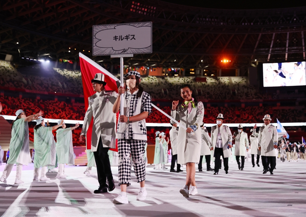Tokyo 2020 Olympics - The Tokyo 2020 Olympics Opening Ceremony - Olympic Stadium, Tokyo, Japan - July 23, 2021. Flag bearers Kanykei Kubanychbekova of Kyrgyzstan and Denis Petrashov of Kyrgyzstan lead their contingent during the athletes' parade at the op