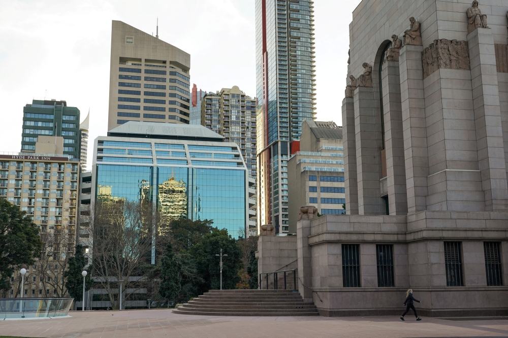 A lone woman walks past the Anzac Memorial as Hyde Park is mostly devoid of people during a lockdown to curb the spread of a coronavirus disease (COVID-19) outbreak in Sydney, Australia, July 22, 2021. REUTERS/Loren Elliott