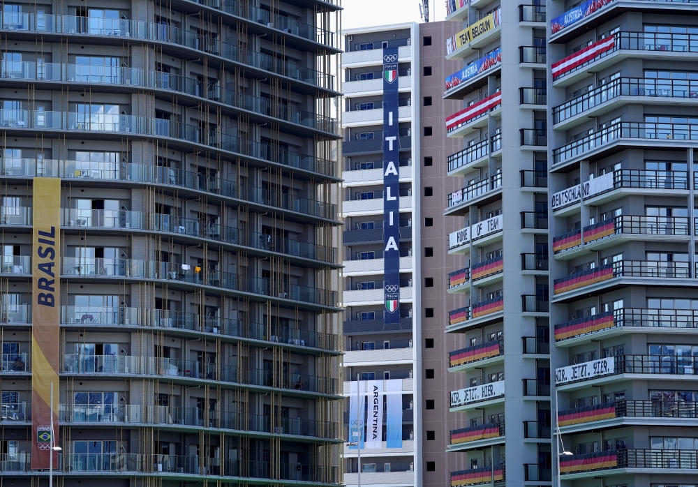 Flags and banners hang at apartment buildings in the athletes' village for the Tokyo 2020 Olympic Games, in Tokyo, Japan, July 22, 2021. REUTERS/Naoki Ogura