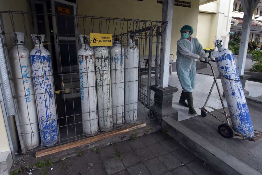 A medical worker pulls an oxygen cylinder to be delivered to the emergency ward at a government-run hospital amid the coronavirus disease (COVID-19) outbreak in Denpasar, Bali, Indonesia, July 23, 2021, in this photo taken by Antara Foto July 23, 2021. An