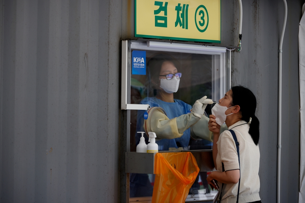 A woman gets a coronavirus disease (COVID-19) test at a coronavirus testing site in Seoul, South Korea, July 15, 2021. REUTERS/Kim Hong-Ji/File Photo
