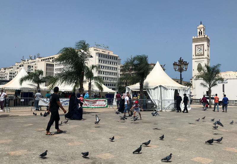 FILE PHOTO: People walk past tents erected during a coronavirus disease (COVID-19) vaccination campaign that is taking place outside mosques, after Friday Prayers in Algiers, Algeria July 9, 2021. REUTERS/Abdelaziz Boumzar
