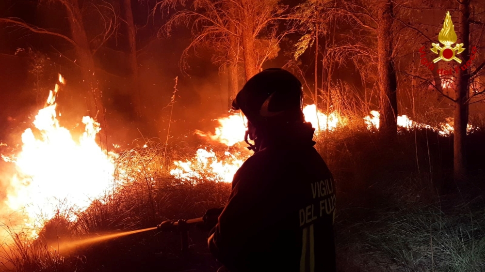 A firefighter battles the flames after a wildfire broke out near the Sicilian village of Erice, Italy July 26, 2021. Vigili del Fuoco/Handout via REUTERS