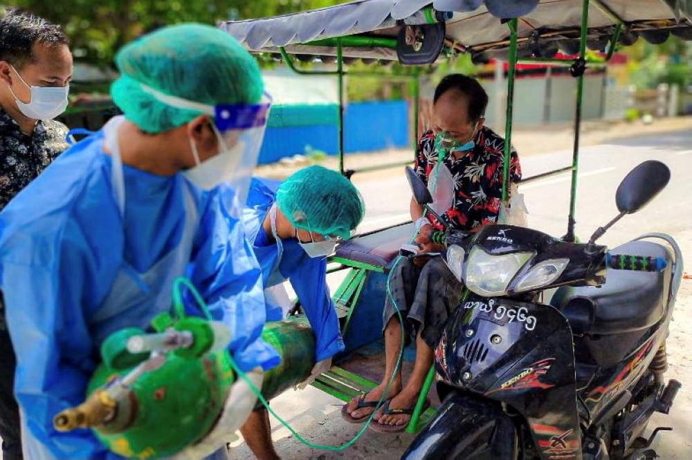 FILE PHOTO: Volunteers help provide a coronavirus (COVID-19) patient with extra oxygen in the town of Kale, Sagaing Region, Myanmar, July 5, 2021. Picture taken July 5, 2021. REUTERS/Stringer/File Photo