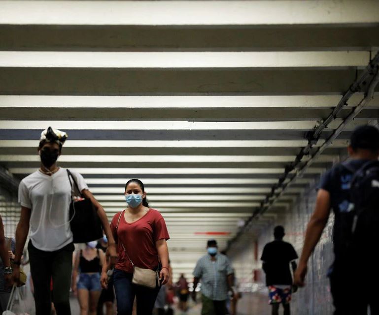 People wear masks as they pass through a pedestrian subway as cases of the infectious coronavirus Delta variant continue to rise in New York City, New York, U.S., July 26, 2021. REUTERS/Andrew Kelly

