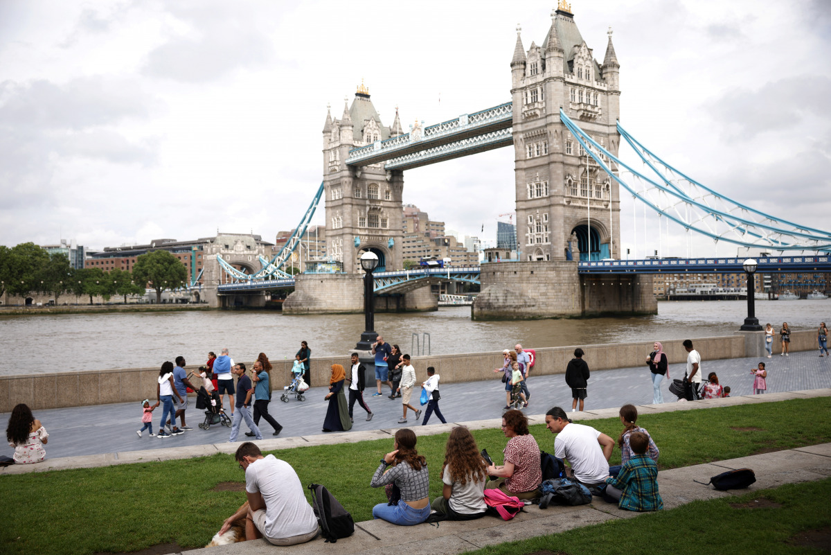 Tower Bridge can be seen as people walk along the River Thames, amid the coronavirus disease (COVID-19) pandemic in London, Britain, July 27, 2021. REUTERS/Henry Nicholls

