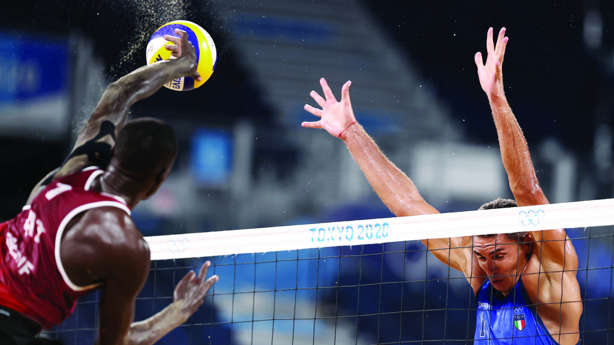 Qatar's Cherif Younousse shoots to score against Italy's Carambula and Rossi during the men's beach volleyball Pool C match played at Shiokaze Park in Tokyo, Japan, yesterday.
