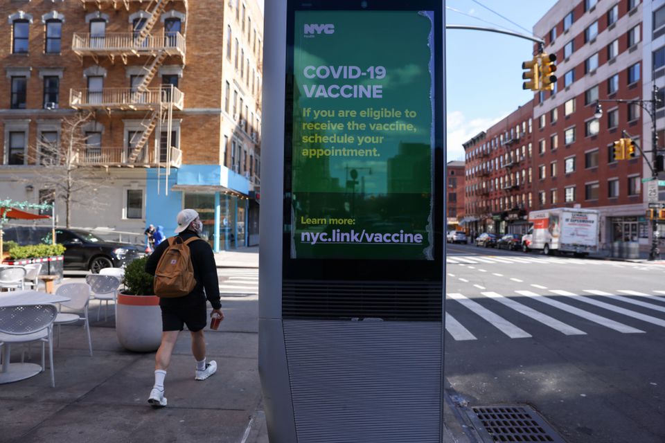 A pedestrian walks past an ad encouraging those eligible to sign up for COVID-19 vaccine appointments in the Manhattan borough of New York City, New York, U.S., March 29, 2021. REUTERS/Caitlin Ochs