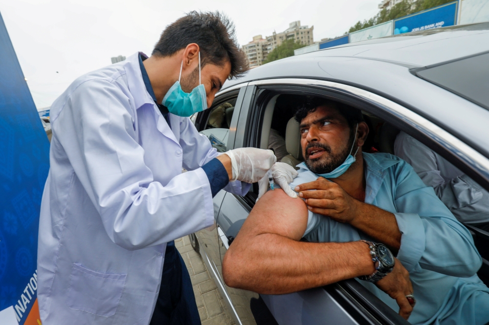 A resident receives a vaccine against coronavirus disease (COVID-19) at a drive-through vaccination facility in Karachi, Pakistan July 29, 2021. REUTERS/Akhtar Soomro/File Photo