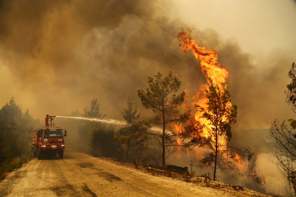 A firefighter extinguishes a forest fire near the town of Manavgat, east of the resort city of Antalya, Turkey, July 30, 2021. REUTERS/Kaan Soyturk
