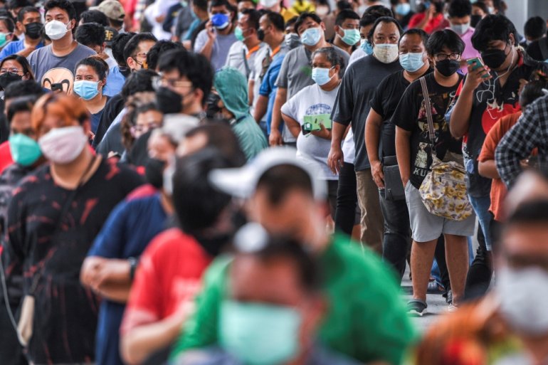 People wearing protective masks queue outside the Central Vaccination Center as Thailand opens walk-in first dose of the AstraZeneca coronavirus disease (COVID-19) vaccination scheme for elders, people with a minimum weight of 100 kilograms and pregnant w