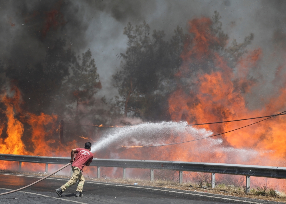 A firefighter tries to extinguish a wildfire near Marmaris, Turkey, August 1, 2021. REUTERS/Umit Bektas