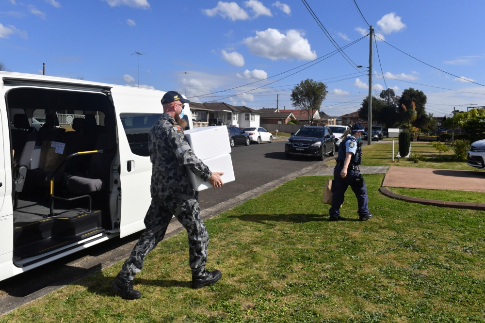 Australian Defence Force personnel and NSW police deliver emergency food parcels for people in lockdown in the Fairfield suburb in the southwest of Sydney, Australia, August 2, 2021. AAP Image/Mick Tsikas via REUTERS