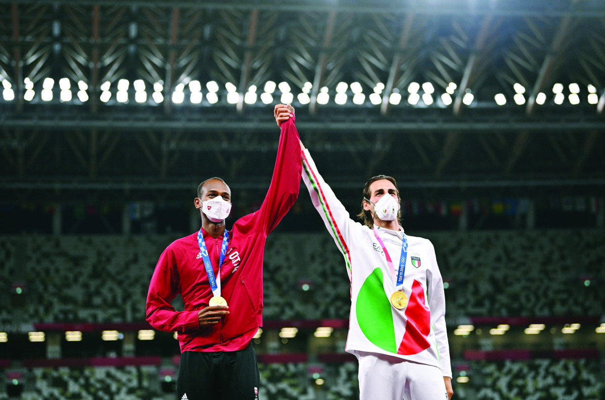 Gold medallists, Mutaz Barshim of Qatar and Gianmarco Tamberi of Italy celebrate on the podium during the medal ceremony of the men’s high jump, yesterday.