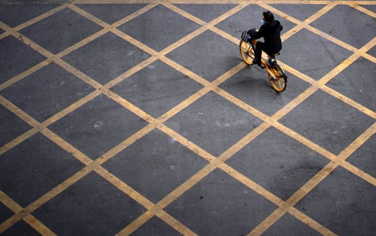 A person wearing a mask rides a bicycle of bike-sharing service on a street, almost a year after the start of the coronavirus disease (COVID-19) outbreak, in Wuhan, Hubei province, China December 17, 2020. REUTERS/Aly Song
