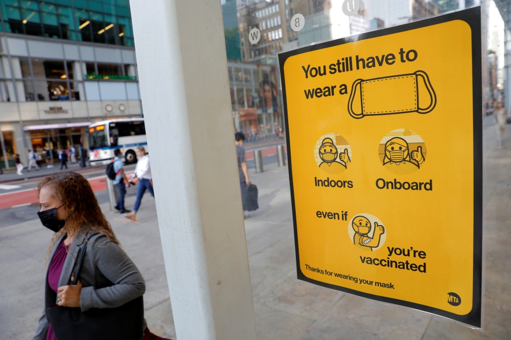 A poster alerting for the wearing of masks is seen on a 42nd Street subway entrance as cases of the infectious coronavirus Delta variant continue to rise in New York City, on August 2, 2021. (REUTERS/Andrew Kelly)