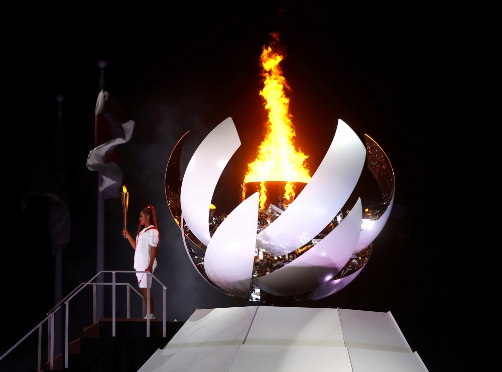 Naomi Osaka of Japan holds the Olympic torch after lighting the cauldron at the Tokyo 2020 Olympics opening ceremony, July 23, 2021. REUTERS/Kai Pfaffenbach/File Photo/File Photo