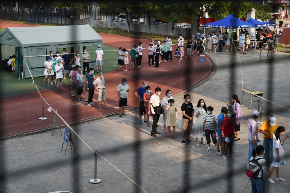 Residents line up at a nucleic acid testing site during a citywide mass testing following new cases of the coronavirus disease (COVID-19) in Wuhan, Hubei province, China, August 3, 2021. Picture taken August 3, 2021. REUTERS/Stringer 