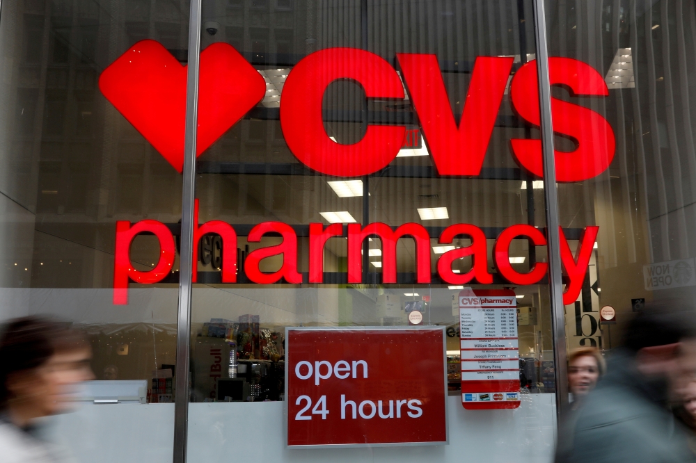 People walk by a CVS Pharmacy store in the Manhattan borough of New York City, New York, U.S., November 30, 2017. REUTERS/Shannon Stapleton/File Photo