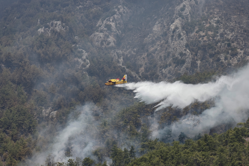 A firefighting plane from Spain drops water to a wildfire near Koycegiz, Turkey, August 4, 2021. REUTERS/Umit Bektas