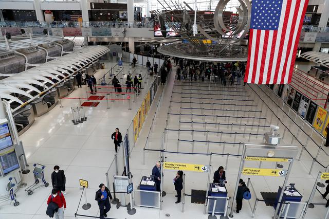 FILE PHOTO: Passengers walk through Terminal 1, after further cases of coronavirus were confirmed in New York, at JFK International Airport in New York, U.S., March 13, 2020. REUTERS/Shannon Stapleton
