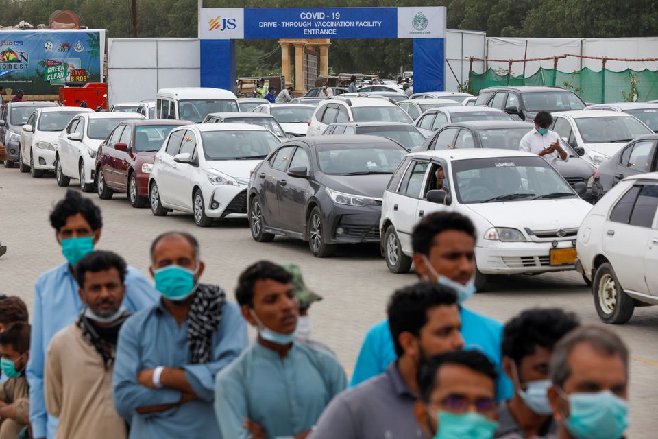 Residents line up to receive a vaccine against coronavirus disease (COVID-19) at a drive-through vaccination facility in Karachi, Pakistan July 29, 2021. REUTERS/Akhtar Soomro