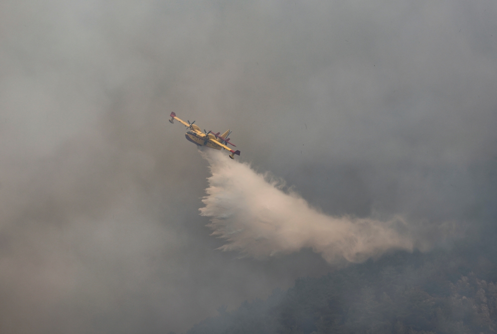 A firefighting plane from Spain drops water to a wildfire near Koycegiz, Turkey, August 4, 2021. REUTERS/Umit Bektas/File Photo