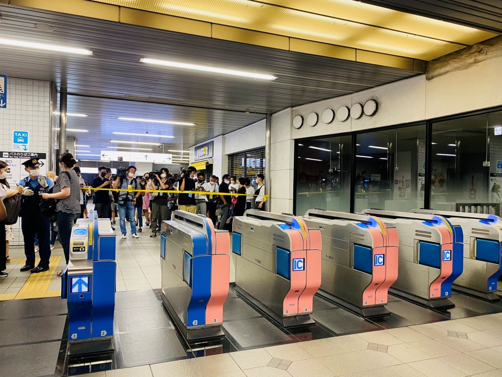 Media members stand behind police tape at a station after a knife attack on a train in Tokyo, Japan August 6, 2021 in this picture obtained from social media. TWITTER/_KING_OF_SKY/via REUTERS