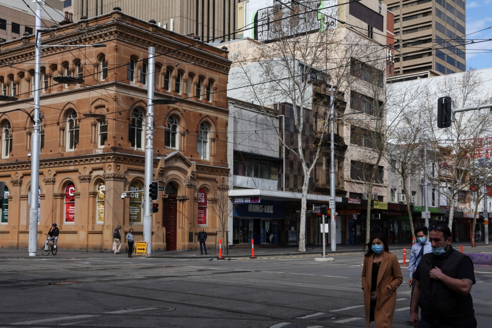 Pedestrians wearing protective face masks walk through the city centre during a lockdown to curb the spread of a coronavirus disease (COVID-19) outbreak in Sydney, Australia, August 9, 2021. REUTERS/Loren Elliott