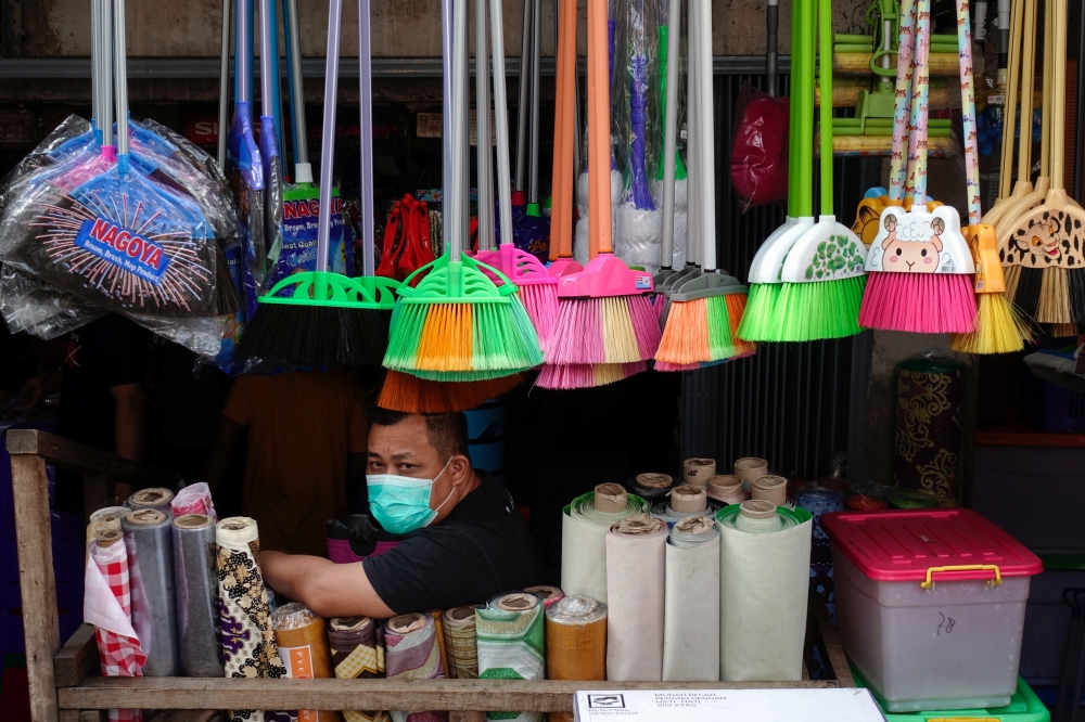 A household goods vendor wearing a protective mask waits for customers amid the coronavirus disease (COVID-19) pandemic in Jakarta, Indonesia, August 9, 2021. REUTERS/Willy Kurniawan